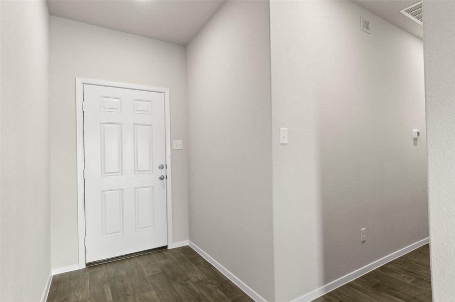 Entryway with dark wood-style flooring and baseboards
