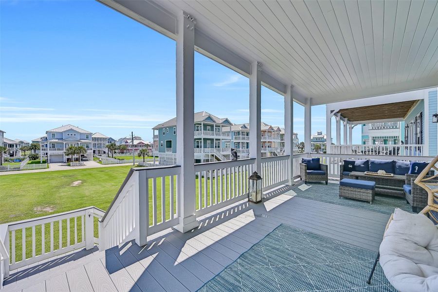 Oversized balcony areas create seamless flow between indoor comfort and outdoor coastal living.  This area is off the kitchen and the stairs lead downstairs to the outdoor shower and the grill.  You can also access the gate to the protected HOA greenspace that leads to the beach walkover.