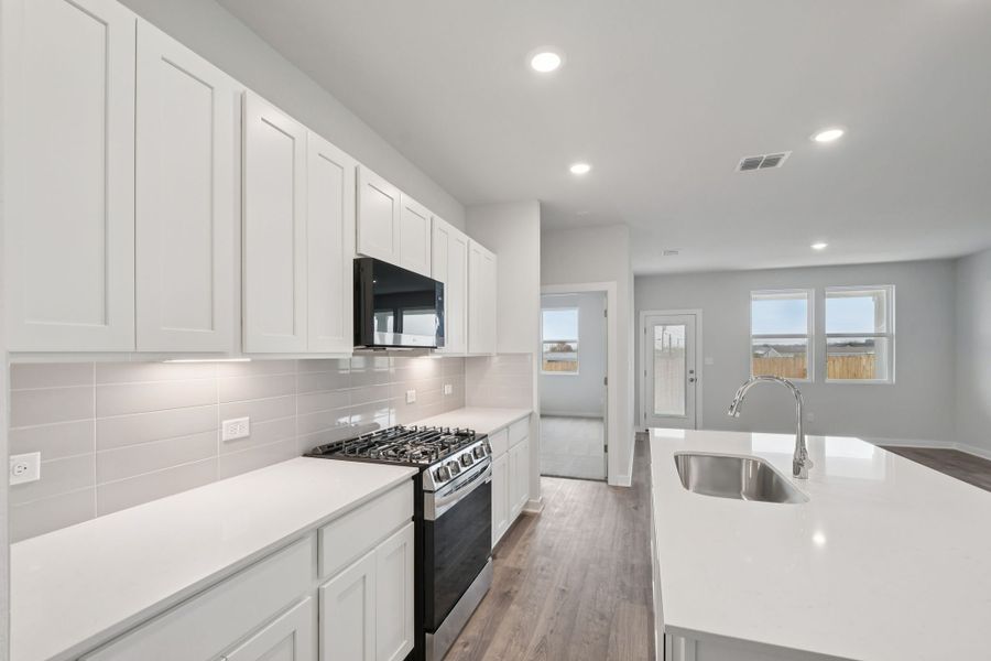 A kitchen with white cabinets.