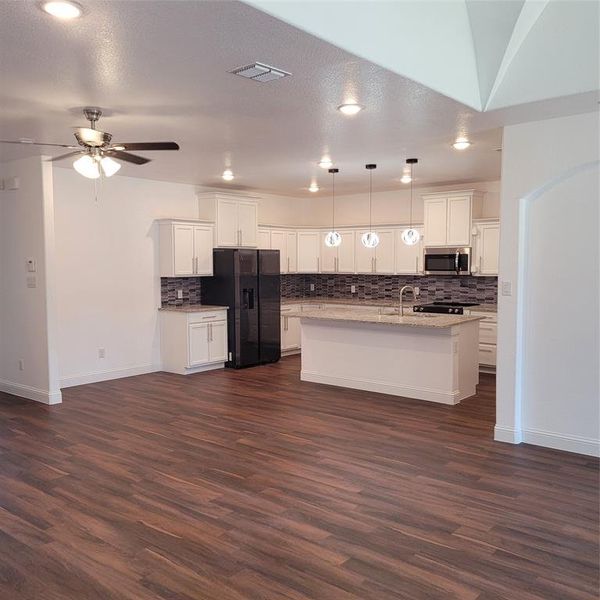 Kitchen featuring white cabinetry, dark hardwood / wood-style floors, paneled built in refrigerator, decorative light fixtures, and ceiling fan