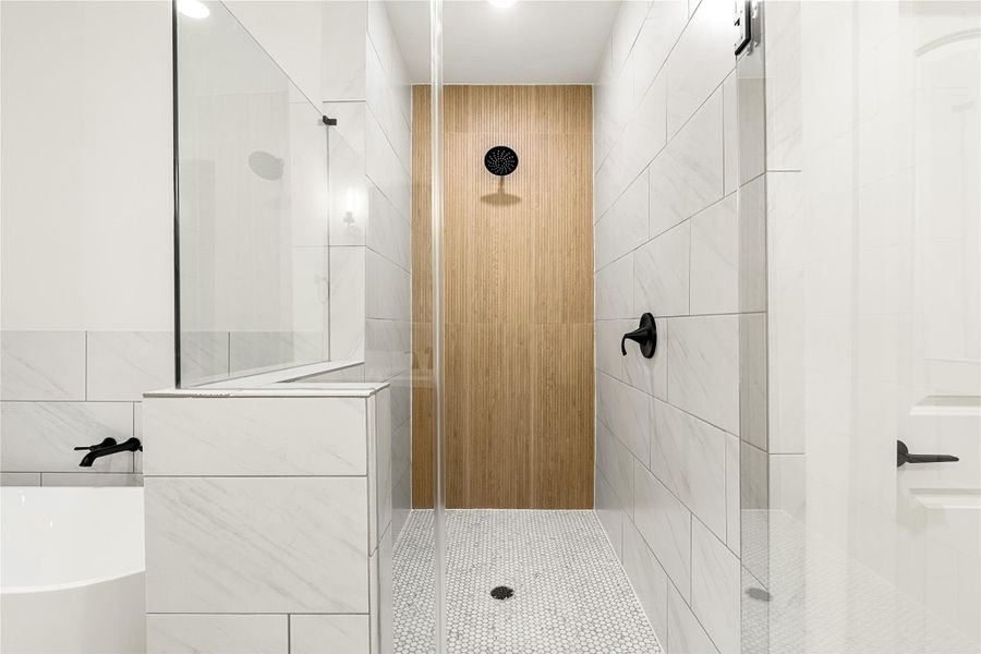 Luxurious walk-in shower featuring sleek white tiles, a stylish wood accent wall, and a built-in niche for conveniently storing your essentials.
