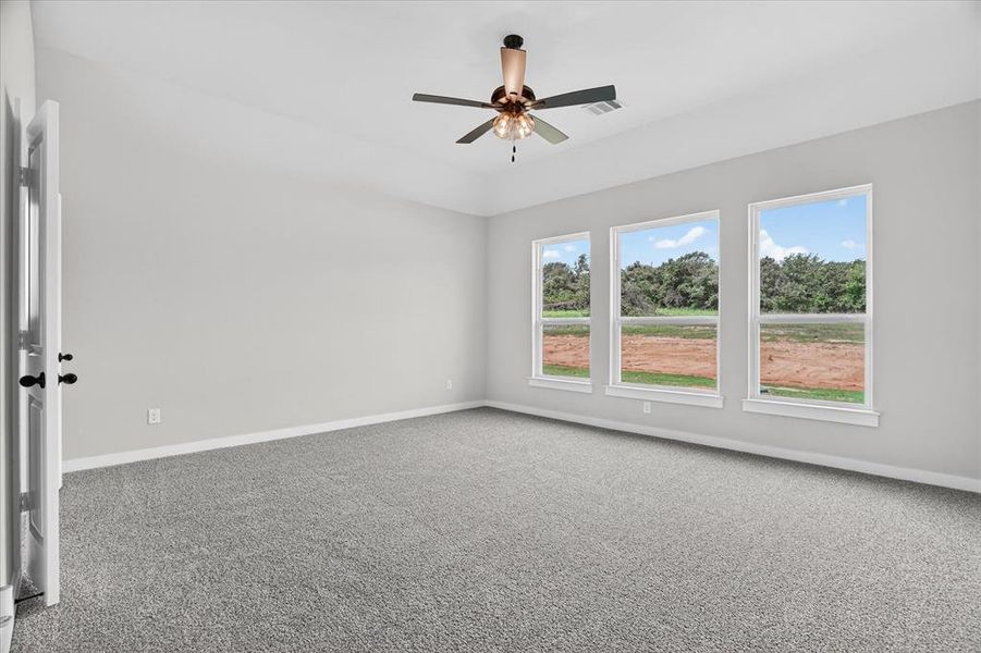 Spacious room featuring vaulted ceilings, light gray wall paint, and gray carpet flooring