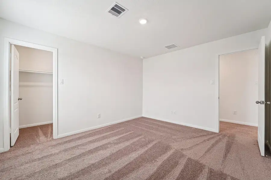 Secondary bedroom view into hallway and walk-in closet