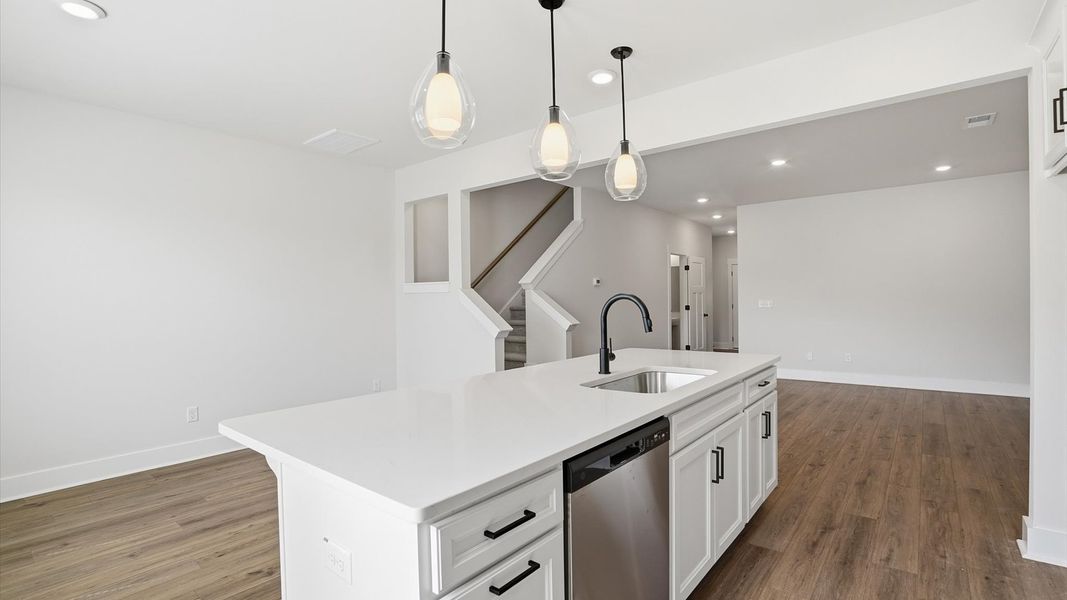 Tasteful design meets functional luxury in this kitchen with a center island and modern pendant lighting by DRB Homes Tasteful design meets functional luxury in this kitchen with a center island and modern pendant lighting by DRB Homes