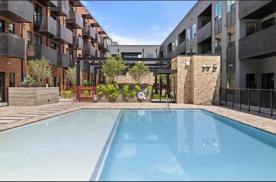 An inviting swimming pool serves as the centerpiece of this modern residential courtyard. An inviting swimming pool serves as the centerpiece of this modern residential courtyard.