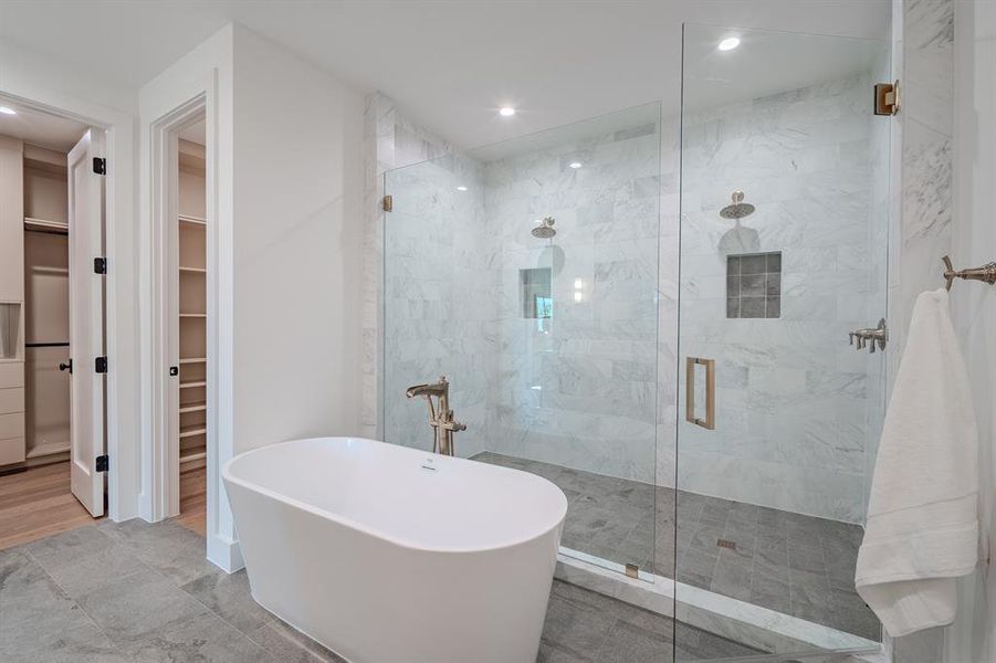Full bathroom with a walk in closet, a stall shower, a soaking tub, and recessed lighting Full bathroom with a walk in closet, a stall shower, a soaking tub, and recessed lighting