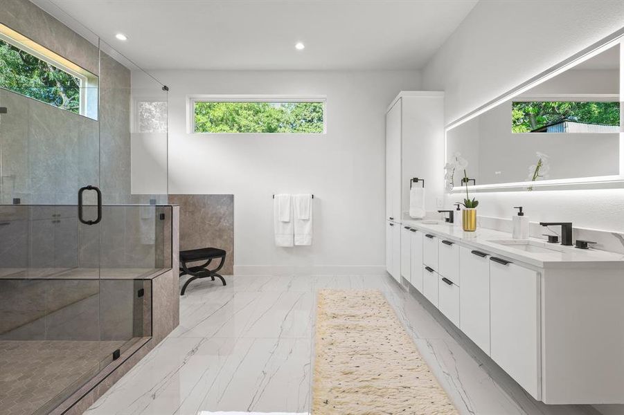 Bathroom with tile patterned floors, a shower with door, and dual bowl vanity