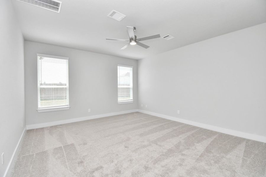 Escape to tranquility in this spacious primary room, adorned with plush carpeting and bathed in the soothing hues of warm paint colors, creating a cozy retreat for relaxation. Sample photo of completed home with similar floor plan. Actual colors and selections may vary. Escape to tranquility in this spacious primary room, adorned with plush carpeting and bathed in the soothing hues of warm paint colors, creating a cozy retreat for relaxation. Sample photo of completed home with similar floor plan. Actual colors and selections may vary.