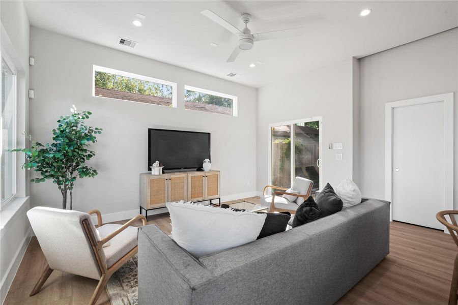 Bright & inviting living room with clerestory windows, a modern ceiling fan & large sliding doors that open to the covered patio for effortless indoor-outdoor living. Bright & inviting living room with clerestory windows, a modern ceiling fan & large sliding doors that open to the covered patio for effortless indoor-outdoor living.