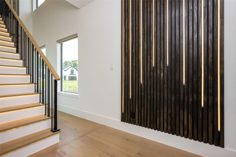 A sculptural staircase showcases white oak treads and sleek, modern iron spindles—both functional and visually captivating A sculptural staircase showcases white oak treads and sleek, modern iron spindles—both functional and visually captivating