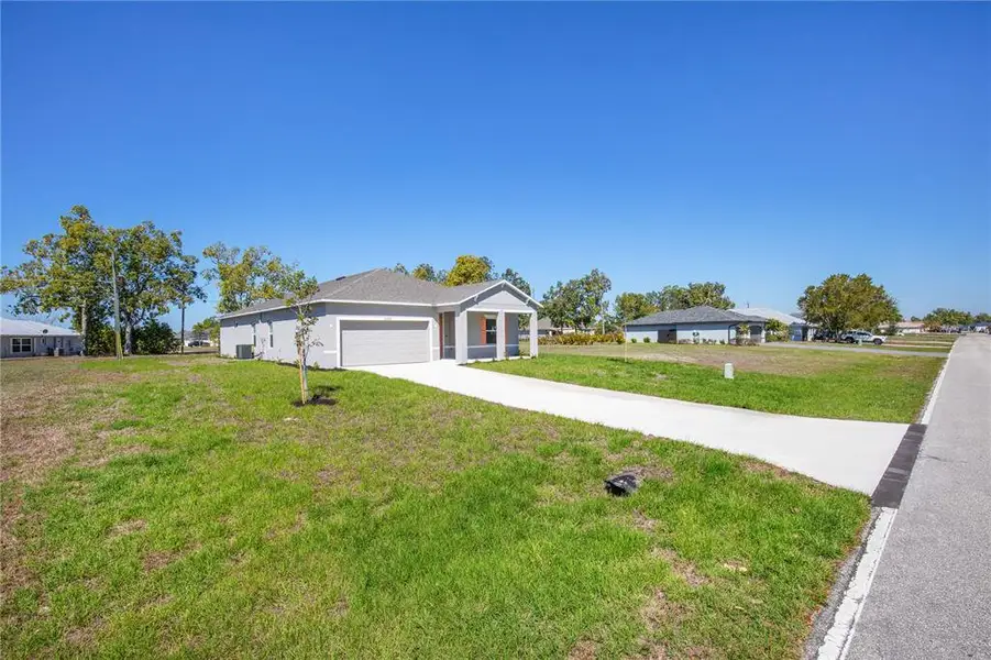 Front exterior of a new home in Burnt Store Village, Punta Gorda, FL, highlighting curb appeal (Image 12).