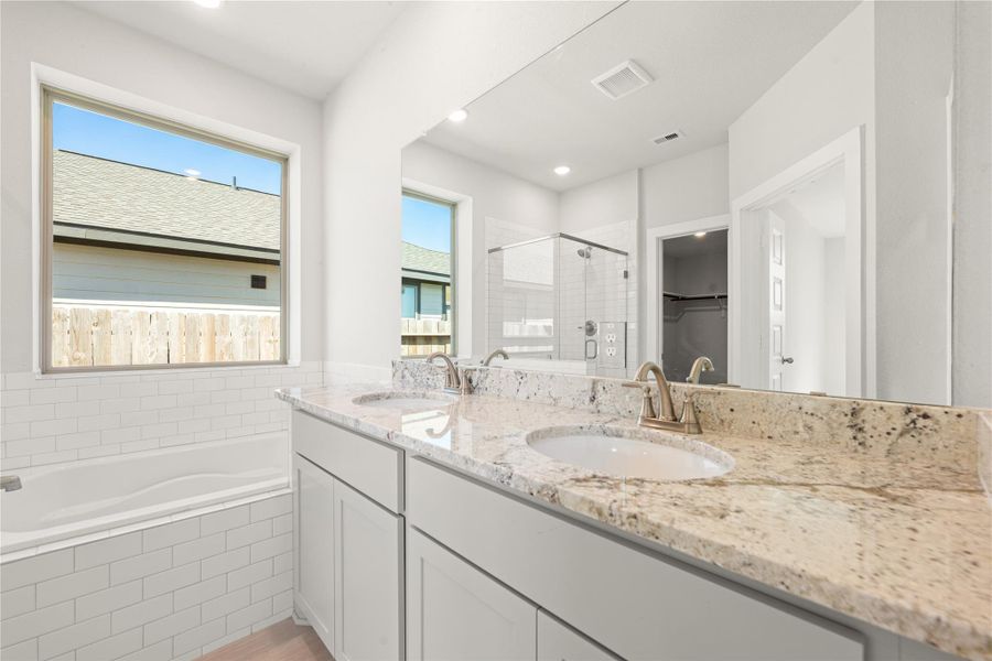 This spa-inspired bathroom showcases dual sinks, a spacious vanity, and a soaking tub beside a large window for natural light. The sleek finishes and neutral palette offer a calm, modern retreat. This spa-inspired bathroom showcases dual sinks, a spacious vanity, and a soaking tub beside a large window for natural light. The sleek finishes and neutral palette offer a calm, modern retreat.