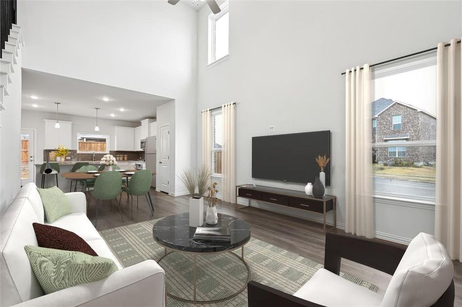 Living room with wood finished floors, a towering ceiling, and baseboards