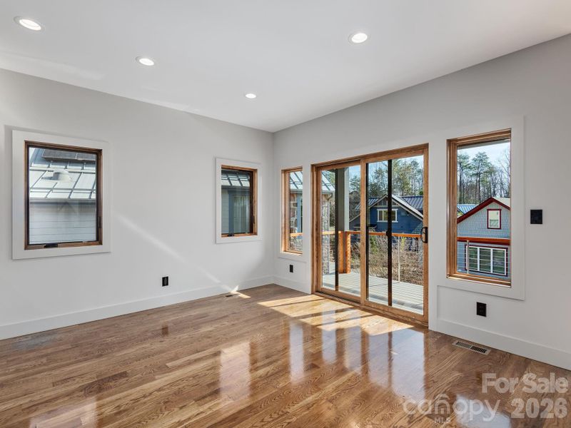 Representative photo from 50 Verde Drive showing the builder’s quality of construction and finish level, including the dining area with oak hardwood floors and large sliding doors opening to the covered deck.