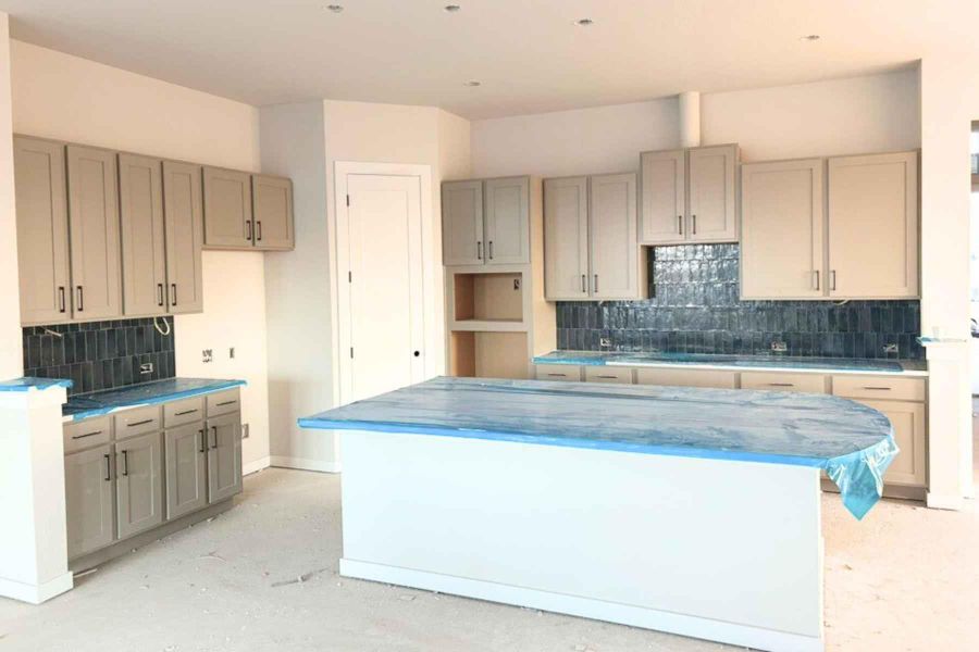 Kitchen featuring tasteful backsplash, gray cabinetry, concrete flooring, and a kitchen island