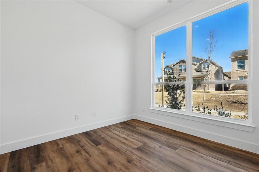 Spare room with baseboards and wood finished floors