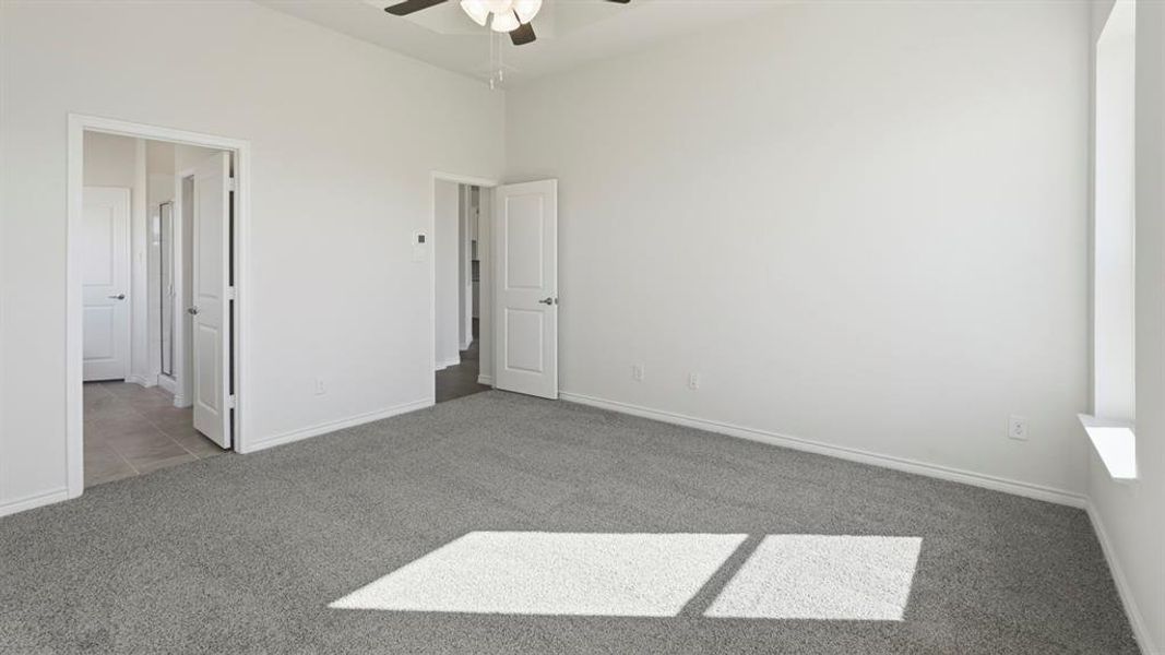 Spacious room featuring light grey carpet, white walls, and a ceiling fan Spacious room featuring light grey carpet, white walls, and a ceiling fan