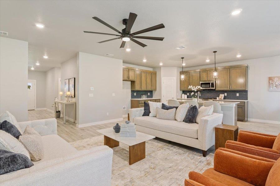 Living area featuring ceiling fan, light wood-style flooring, and recessed lighting Living area featuring ceiling fan, light wood-style flooring, and recessed lighting