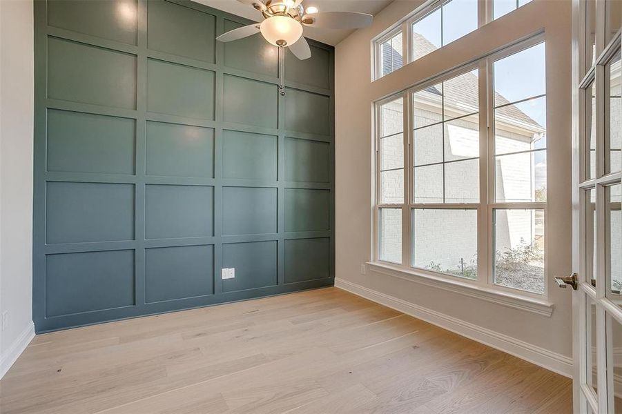 Unfurnished room with ceiling fan, light wood-type flooring, and a wealth of natural light