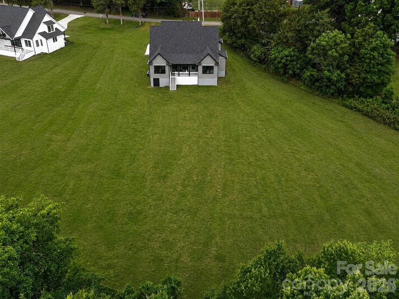 Concept Grass - Enjoy the privacy and space of this expansive 2-acre homesite with a large open backyard bordered by mature trees.