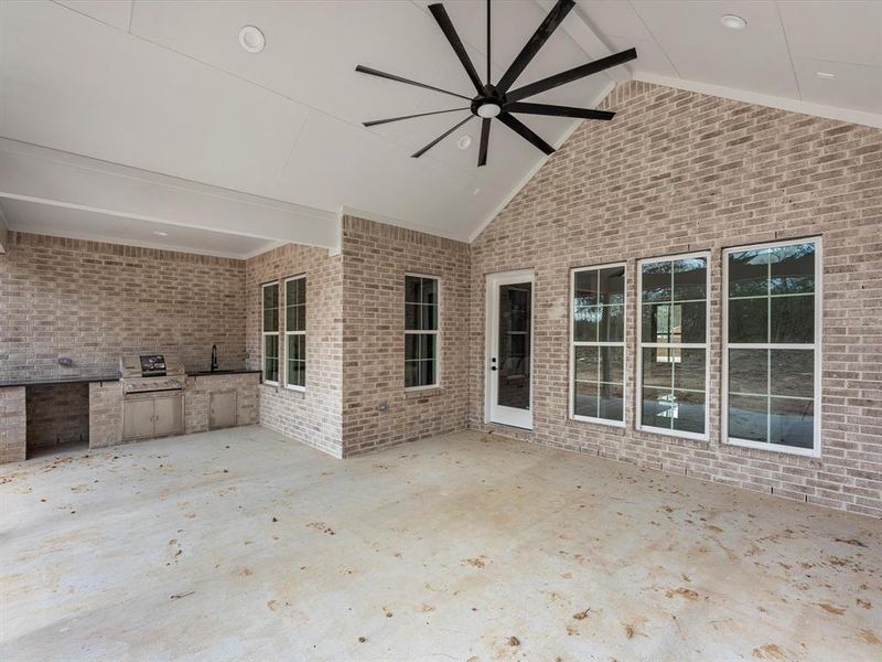 The oversized backyard patio is enhanced by an oversized black ceiling fan, and a fully equipped kitchen powered by propane.