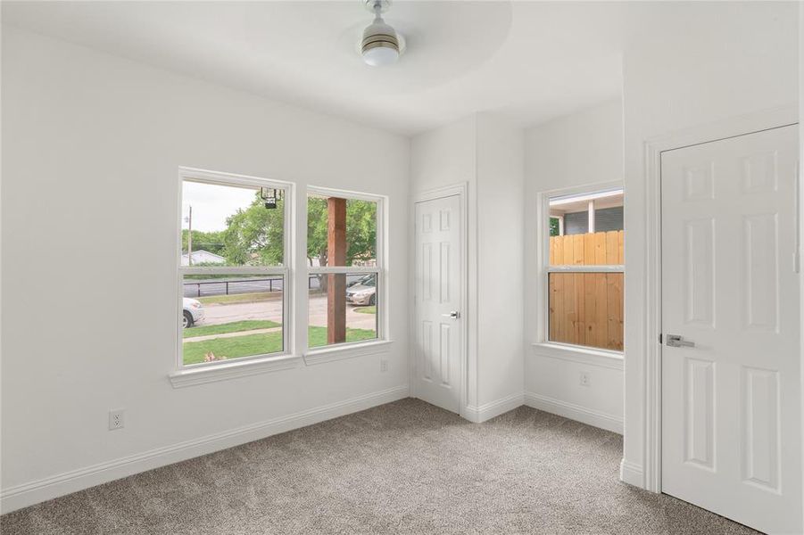Neutral-toned carpeting, white baseboards, and white painted walls