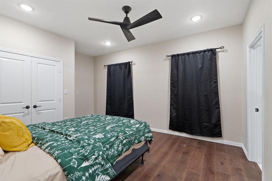 Bedroom featuring dark wood-style floors, a ceiling fan, recessed lighting, and a closet Bedroom featuring dark wood-style floors, a ceiling fan, recessed lighting, and a closet