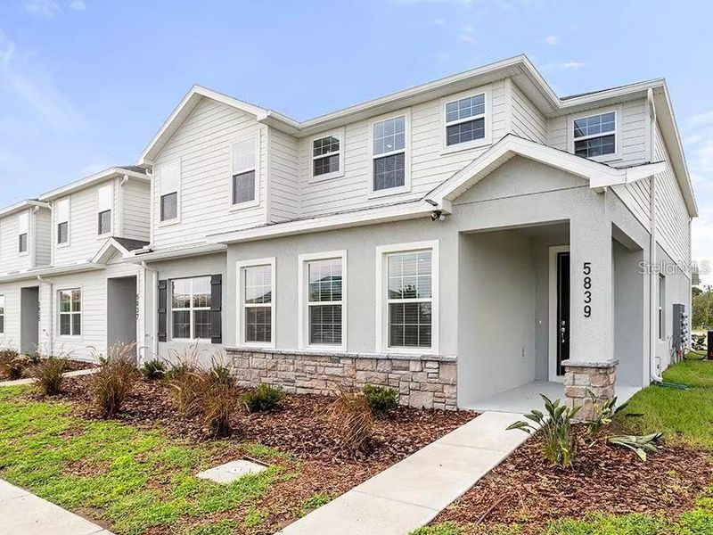Front exterior of a new home in The Crossings - Townhomes, St. Cloud, FL, highlighting curb appeal (Image 1).