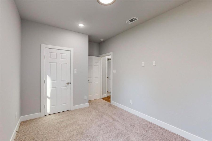 Unfurnished bedroom with light carpet