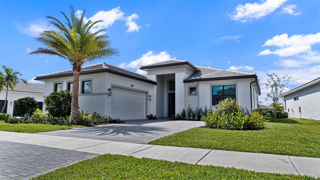 Front exterior of a new home in Cresswind Palm Beach at Westlake, Westlake, FL, highlighting curb appeal (Image 22). Front exterior of a new home in Cresswind Palm Beach at Westlake, Westlake, FL, highlighting curb appeal (Image 22).