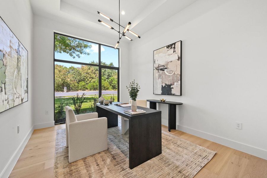 Office area with a chandelier and light wood-style flooring
