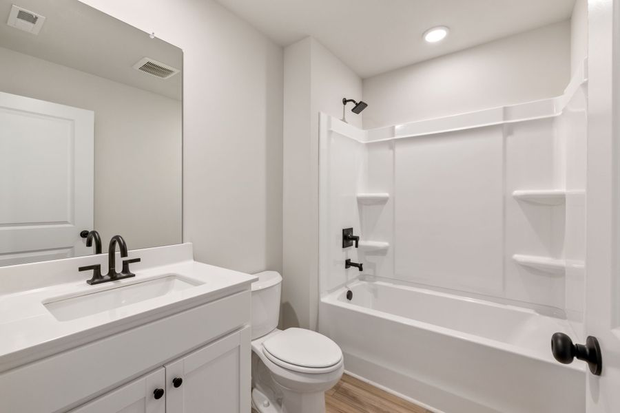 A bathroom with a tub toilet and sink.
