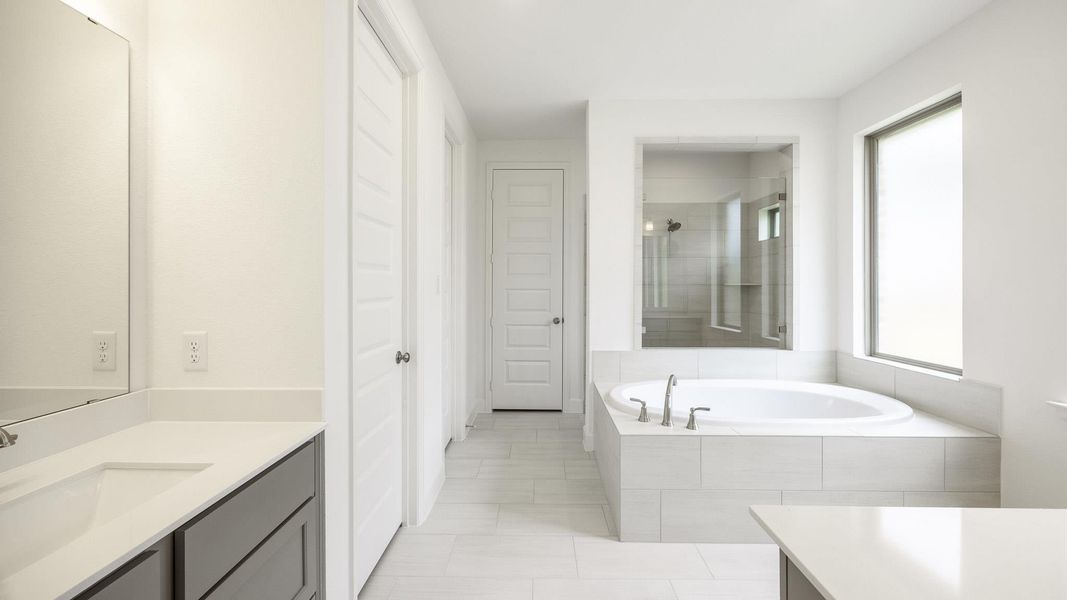 Bathroom featuring vanity, a bath, and tile patterned floors Bathroom featuring vanity, a bath, and tile patterned floors