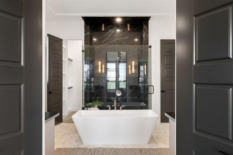 Bathroom featuring a freestanding tub, a shower stall, and marble finish floors Bathroom featuring a freestanding tub, a shower stall, and marble finish floors
