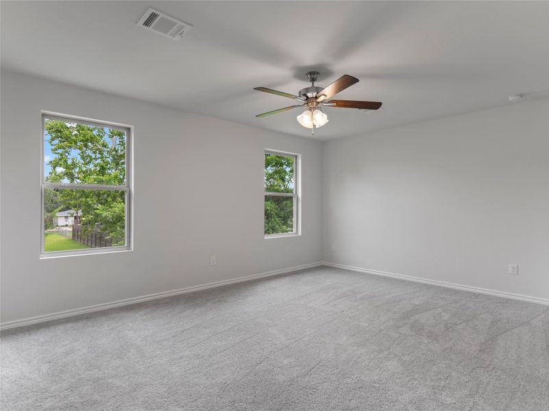 Spacious upstairs bedroom with plush carpet and natural light.
