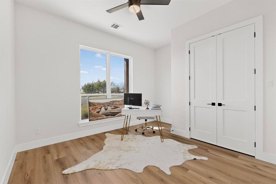 Office area featuring light wood-style flooring and ceiling fan