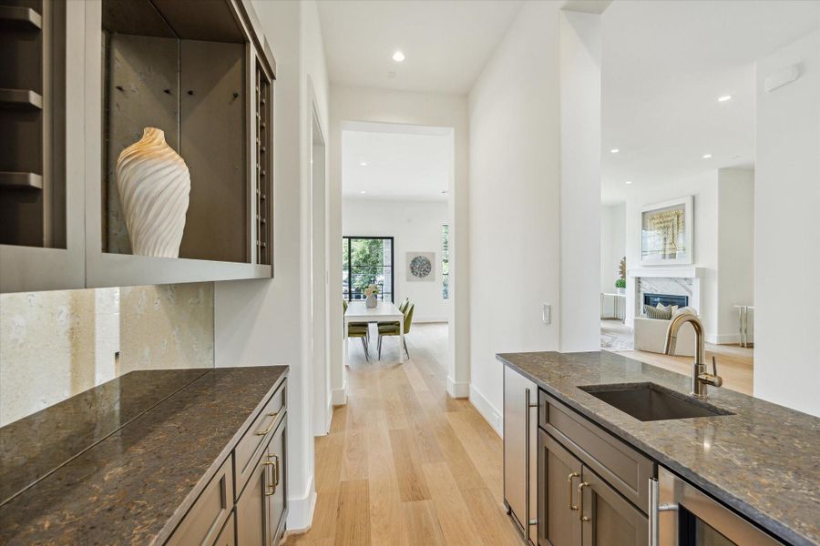 Centrally located entertaining bar - features built-in wine rack, wine/beverage cooler, ice-maker, cabinets and quartz countertops.