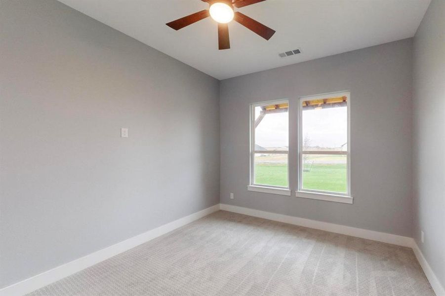 Carpeted spare room with ceiling fan