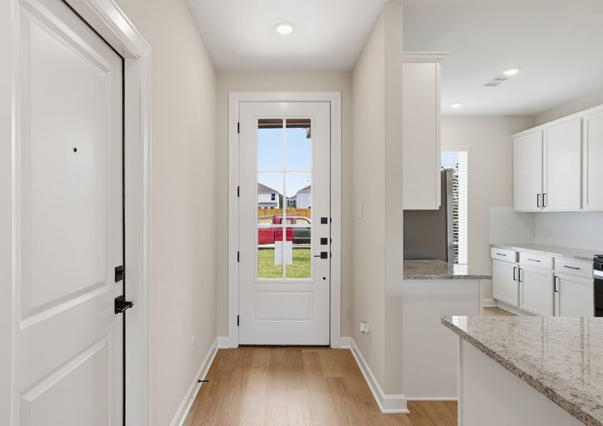 Hallway featuring a door with a window and a view into the kitchen.