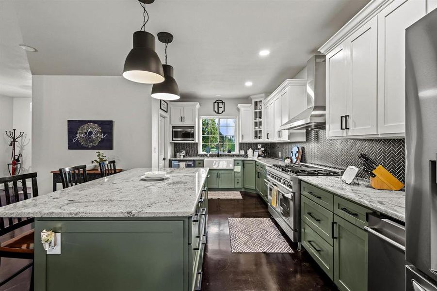 Kitchen with green cabinetry, light stone countertops, a breakfast bar area, tasteful backsplash, and white cabinetry Kitchen with green cabinetry, light stone countertops, a breakfast bar area, tasteful backsplash, and white cabinetry