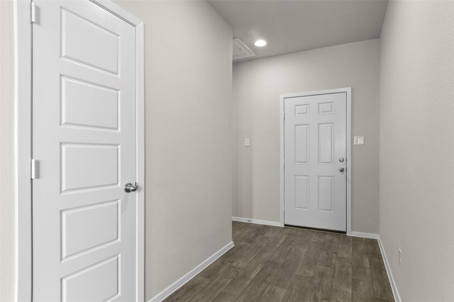 Doorway to outside featuring dark wood-type flooring and recessed lighting