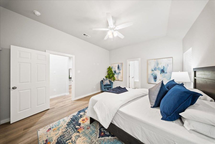 Bedroom featuring wood finished floors, a ceiling fan, and ensuite bathroom Bedroom featuring wood finished floors, a ceiling fan, and ensuite bathroom