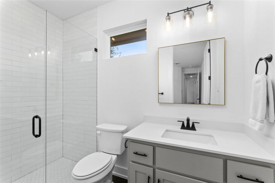 Full bath with vanity, toilet, and a stall shower Full bath with vanity, toilet, and a stall shower