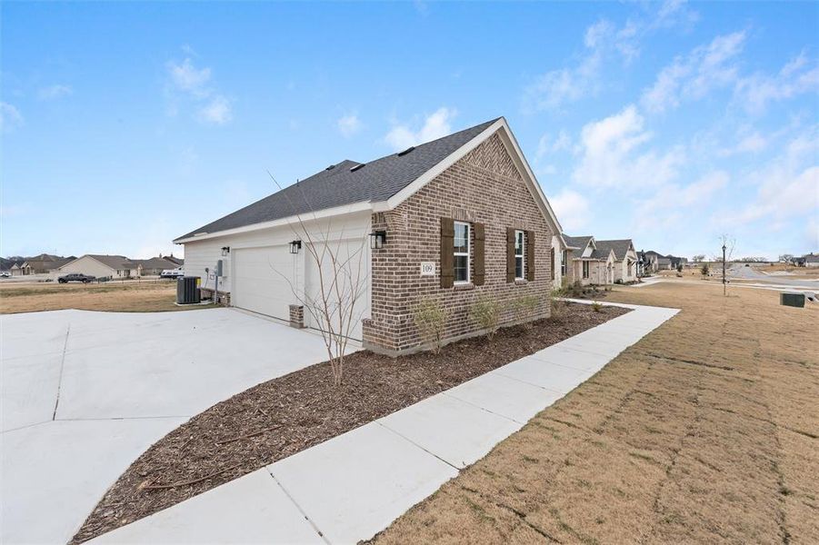 View of property exterior featuring brick siding, driveway, a yard, and a residential view View of property exterior featuring brick siding, driveway, a yard, and a residential view