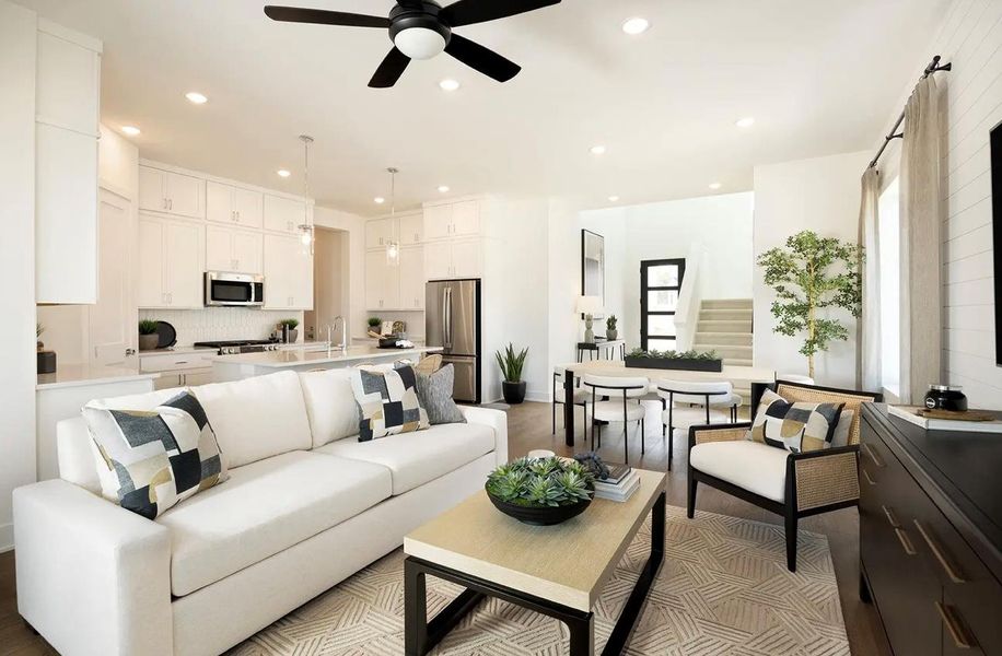 Living area with a ceiling fan, recessed lighting, and stairs