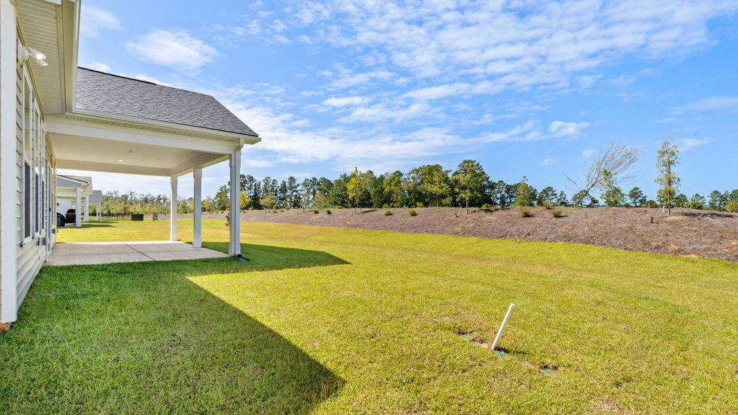 Relax outdoors on a large covered patio with open backyard views.