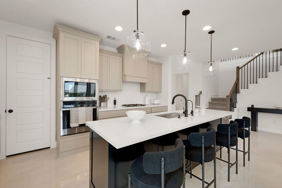 A contemporary kitchen features a spacious island with seating, integrated appliances, and elegant pendant lighting. A contemporary kitchen features a spacious island with seating, integrated appliances, and elegant pendant lighting.