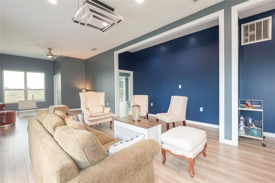 Sitting room with healthy amount of natural light, wood finished floors, a ceiling fan, and recessed lighting Sitting room with healthy amount of natural light, wood finished floors, a ceiling fan, and recessed lighting