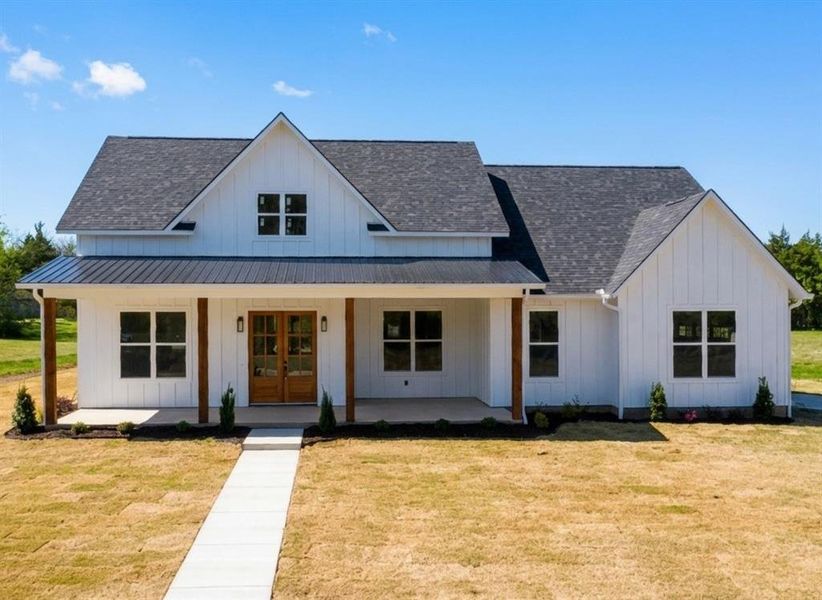 Modern inspired farmhouse featuring board and batten siding, a porch, a front yard, and a shingled roof