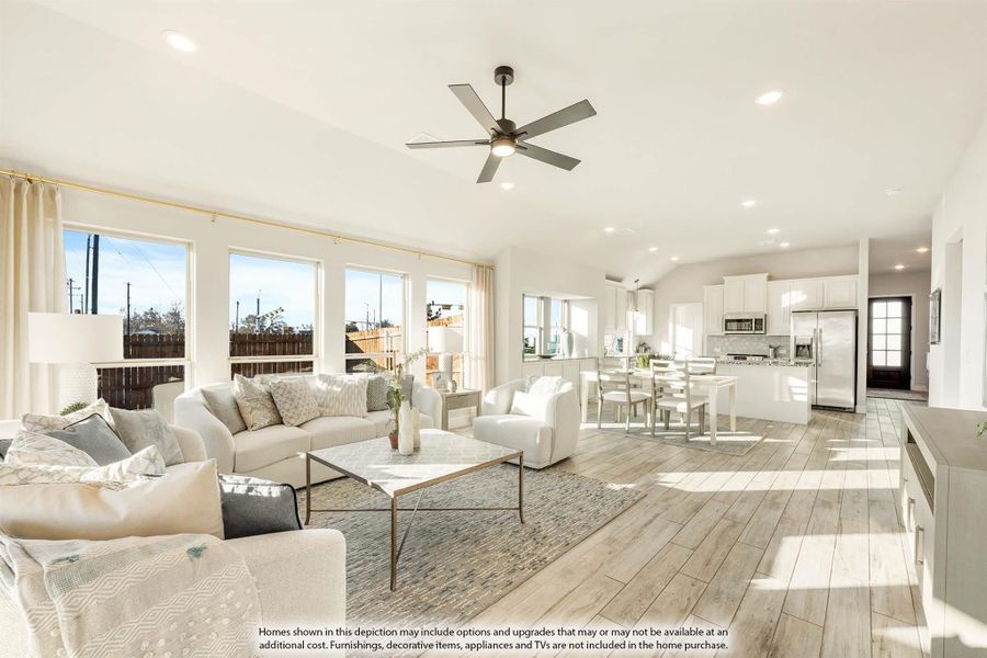 Open-concept living room and kitchen with light wood floors, ceiling fan, and large windows Open-concept living room and kitchen with light wood floors, ceiling fan, and large windows